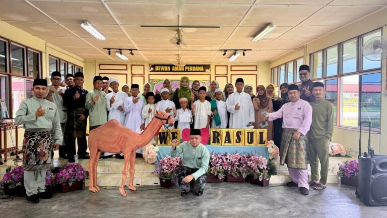 Guru dan murid yang terlibat dengan sambutan Maulidul Rasul bergambar kenangan di dewan utama sekolah.